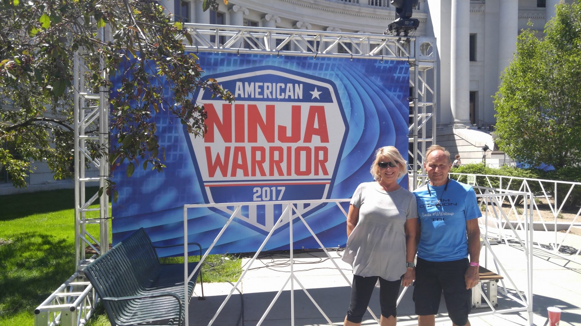 Two people by American Ninja Warrior 2017 banner