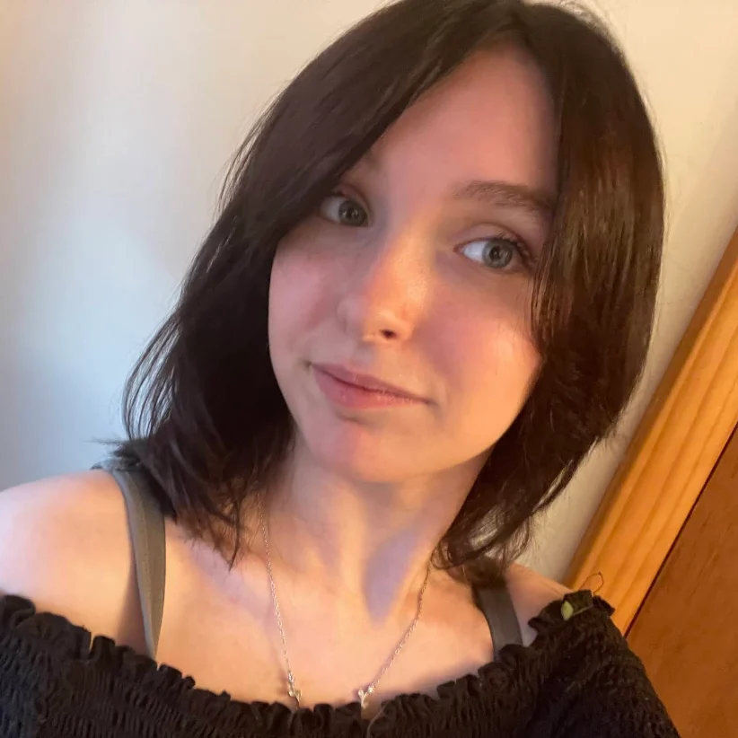 Young woman with dark hair wearing off-shoulder top