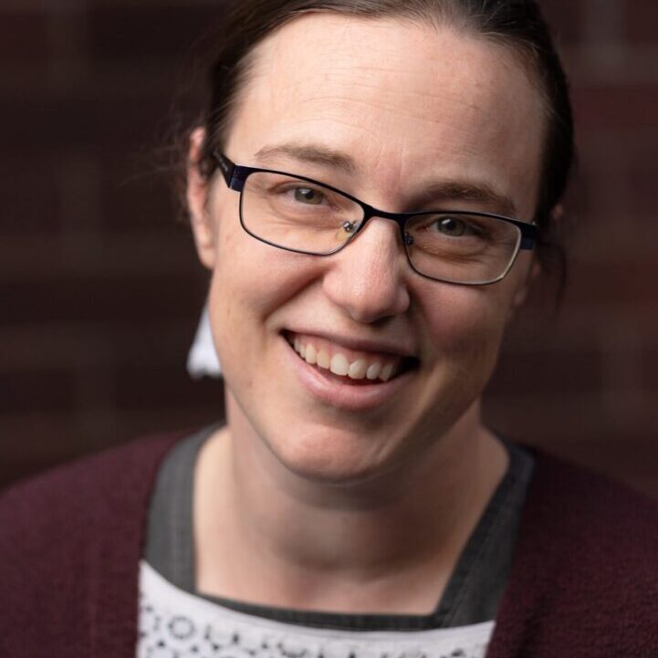 Smiling woman wearing glasses and cardigan