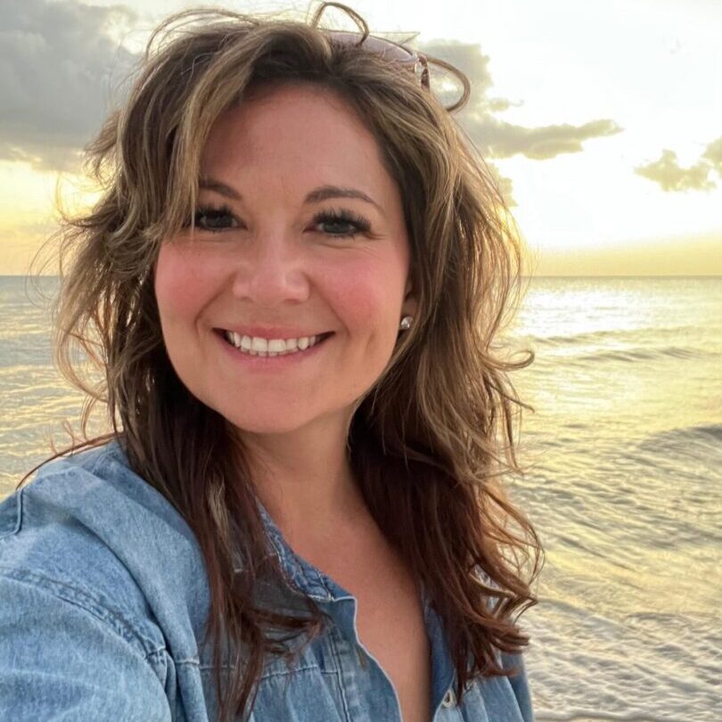 Smiling woman taking selfie at sunset beach